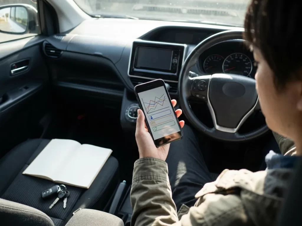 車内で返済額をスマホ確認する日本人の手元